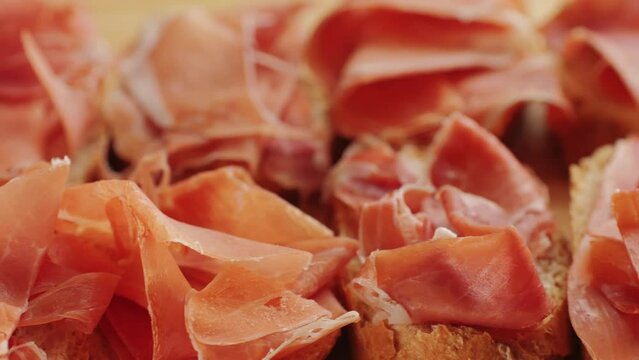 Jamon iberico tapas close up, chef cooking the best spanish ham pork tapas, cafe with traditional food.