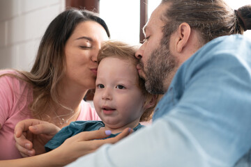 After the little boy wakes up from his nap, his father and mother engage in enjoyable activities in his bedroom.