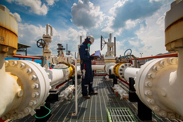 Male worker inspection at steel long pipes and pipe elbow in station oil factory during refinery...
