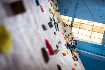 Obraz premium Young girl at indoor rock climbing facility