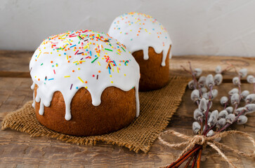 Two Traditional Ukrainian kulich on a burlap napkin with willow buds on a wooden background. The...