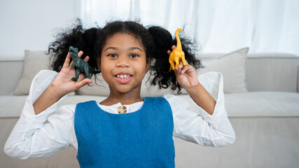 Child playing with colorful toy dinosaurs. Educational toys for kids. Little girl learning fossils...