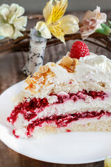 Layer fruit cake with meringue topping and raspberry sauce.