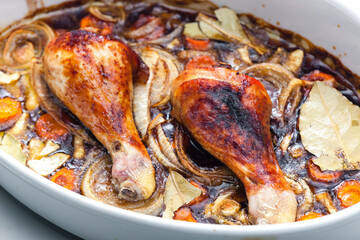chicken legs baked with onion, carrot and bay leaves