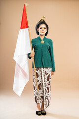 asian woman in green kebaya standing bring the Indonesian flag on isolated background