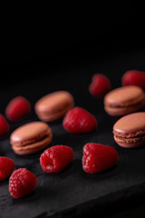 macaroons of different colors on a black background