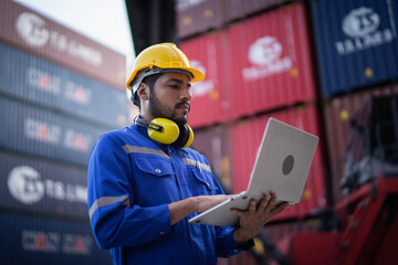 Foreman using laptop computer control or check inventory details of containers box, worker checking...