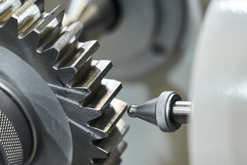 Grey cogwheel and oil nozzle in manufacturing workshop
