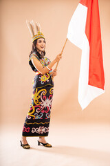 asian woman in king bibinge standing and waving the indonesian flag on isolated background