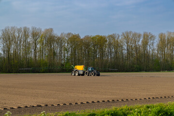 Tractor with sprayer during spring work on the field