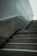Vertical shot of stairs outdoors with a metal handrail with light sky