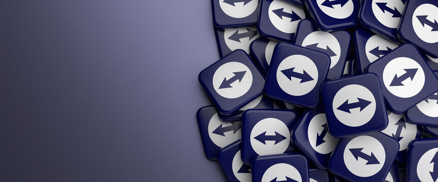 Logos of Teamviewer the software for remote access and remote control of computers on a heap on a table. Web banner format, copy space.