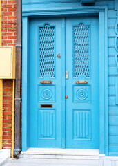 Old blue metal door with brick frame.