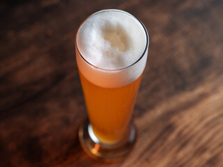 Glass of wheat german beer on wooden table
