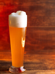 Glass of wheat german beer on wooden table