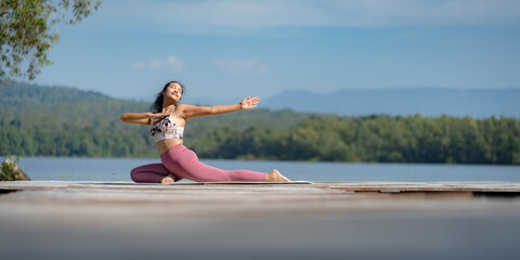 Beautiful attractive Asian woman practice fitness yoga pose on the pool above the Mountain peak in front of nature lake views, Feel so comfortable lifestyle and relax exercise in holiday morning