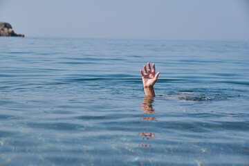 Hand of person drowning in water.