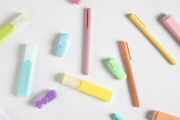 Stationery, pens, colored markers on a white background. Top view, flat lay
