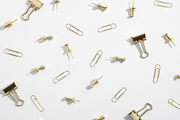 Stationery, paper clips, binders, buttons on a white background. Top view, flat lay