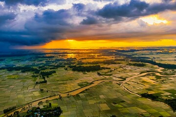 Aerial of a landscape with beautiful farmlands at sunset under the cloudy sky in Bangladesh © Sha Jaman/Wirestock Creators