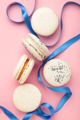 Fototapeta premium Light cake macaron or macaroon with ribbon on pink background. Sweet background.