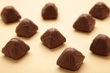 Chocolate candies on beige background. Top view