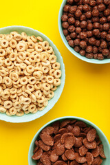 Set of various breakfast cereals on yellow background. Vertical photo