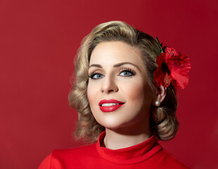 Retro hairstyle woman against a red background. Pin-up woman portrait