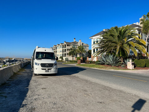 A RV Van parked a long side the beach during the day while on a road trip in St. Simeons Island, GA.