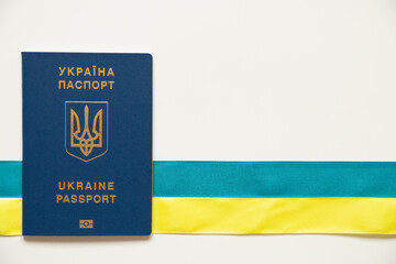 Foreign biometric passport and tape lie horizontally in the colors of the flag of Ukraine on a...