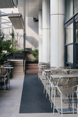 tables and chairs in outdoor exterior, white architecture background