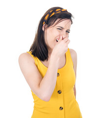 Dissatisfied woman holding finger on nose has disgusting expression on face,something stinky, isolated on white background