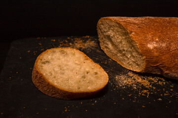 Fresh crispy sliced bread on a black background with copy space.