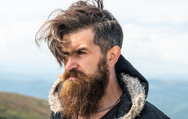 unshaven brutal man having moustache. photo of brutal man in the mountain. brutal man outdoor