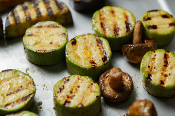 Grilled vegetables on a metal tray. Zucchinis and champignon mushrooms cooked on grill for lunch