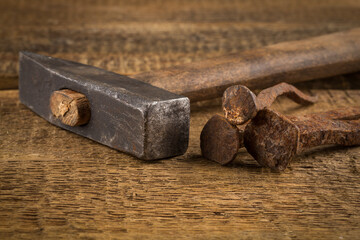 Vintage hammer with nails on wood background