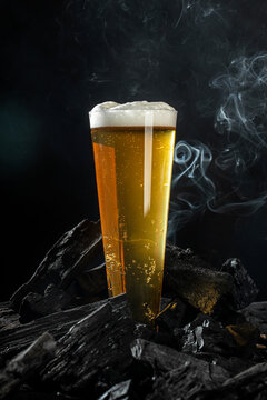 a glass of fresh beer on coals with smoke, vertical image. place for text