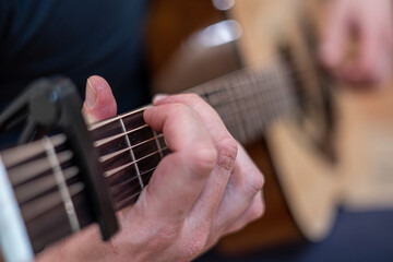 male hands playing acoustic guitar, close up.Acoustic guitar with a beautiful wood .