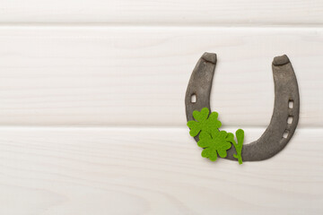 Horseshoe with clover on wooden background, top view. St. Patricks day concept