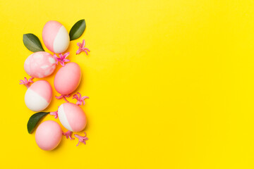 Pink Easter eggs with decor on color background, top view