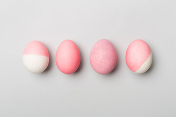Pink Easter eggs with decor on color background, top view