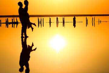 A happy couple at sea with water reflection silhouette background