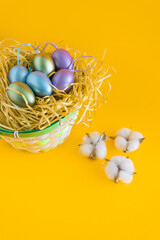 Multicolored Easter eggs in a basket on a bright orange festive background. Happy easter.Greetings and presents for Easter Day celebrate time. Flat lay ,top view.