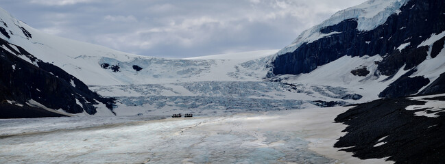 The Athabasca Glacier in the Jasper Icefield in Canada with trucks and hikers on the glacier