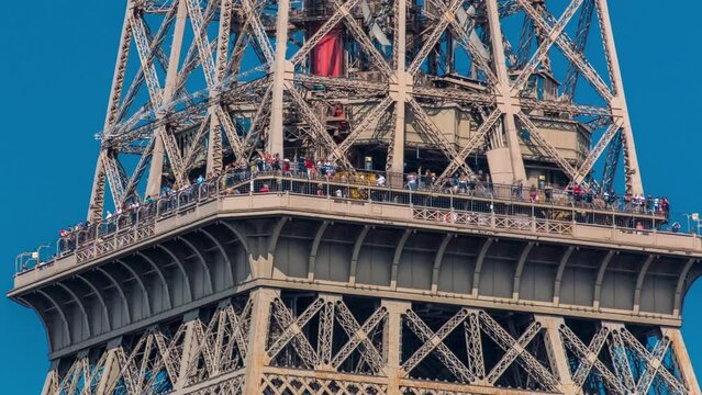 Close up view of middle section of the Eiffel Tower with tourists on observation deck timelapse in Paris, France. People enjoying the view of the city from above