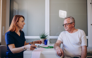 doctor talking to her male senior patient at office