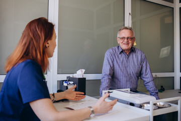 Fototapeta premium Cheerful elderly man being examined by a medical worker