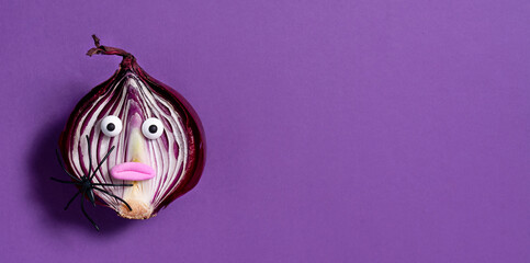 Halloween background. Spooky onion on a purple background. Halloween food. Banner.