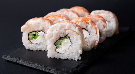 Asian sushi. Sushi with shrimps on a dark background. Japanese cuisine. Side view.