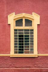 Framed window on a red wall as seen from exterior